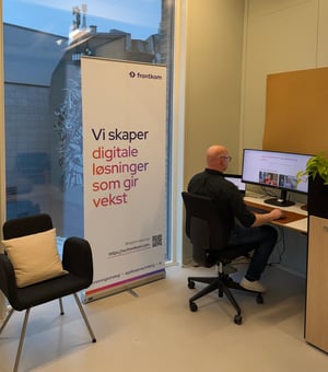 Plakat og en person som jobber ved en PC